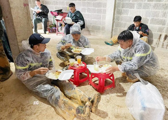 Bữa trưa khi quần áo còn lấm lem bùn đất của các chiến sỹ Cảnh sát cơ động.
