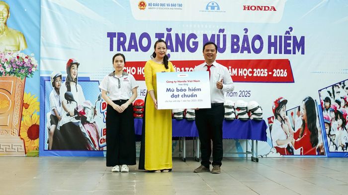 Đại diện HEAD Sơn Minh trao mũ bảo hiểm cho lãnh đạo nhà trường.