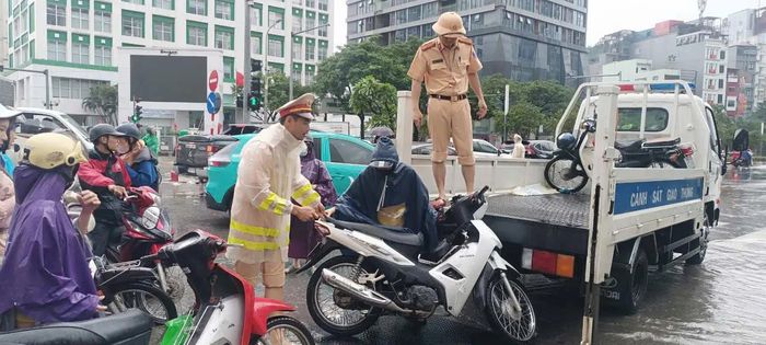 Cảnh sát giao thông sử dụng xe chuyên dụng đưa người dân qua điểm ngập, bảo đảm an toàn.