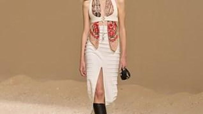 Thương hiệu cũng làm mới khăn lụa Hermès, biến hóa món phụ kiện thành cấu trúc trang phục. Khăn được tết xen kẽ với dây chuyền để tạo thành một chiếc choker thanh lịch, hay quấn quanh gáy và buông rủ xuống trước ngực thay cho áo. 
