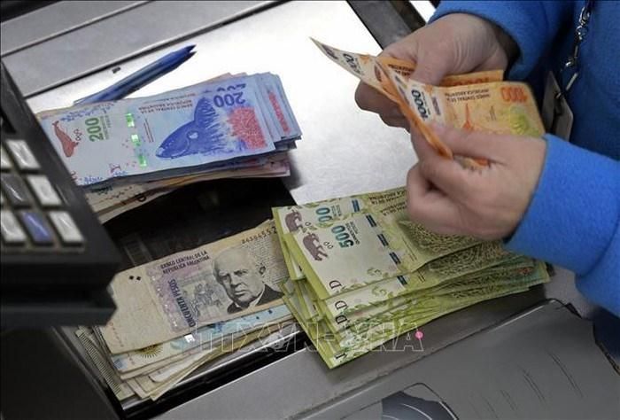 Kiểm đồng peso của Argentina tại một siêu thị ở Buenos Aires. Ảnh: AFP/TTXVN