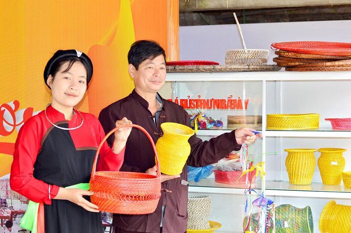 Anh Lâm Văn Quán và con gái giới thiệu sản phẩm mây tre đan truyền thống của gia đình.