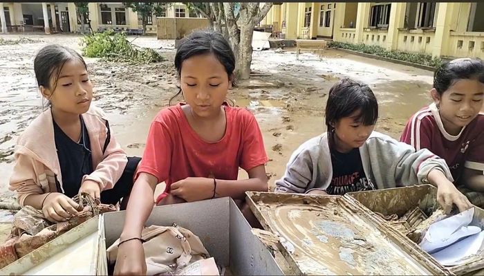 Học sinh xã Yên Hòa, tìm sách vở trong bùn đất.