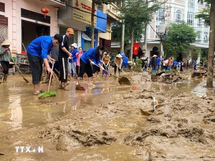 Các lực lượng thanh niên tình nguyện được huy động để giúp dân dọn dẹp nhà ở, vệ sinh đường phố. (Ảnh: TTXVN)
