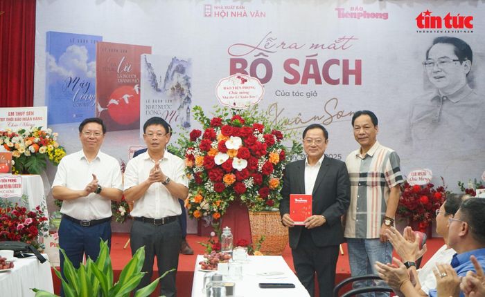 Nhà báo, nhà thơ Lê Xuân Sơn, nguyên Tổng Biên tập báo Tiền Phong đón nhận món quà và lẵng hoa của Tổng Biên tập báo Tiền Phong Phùng Công Sưởng.