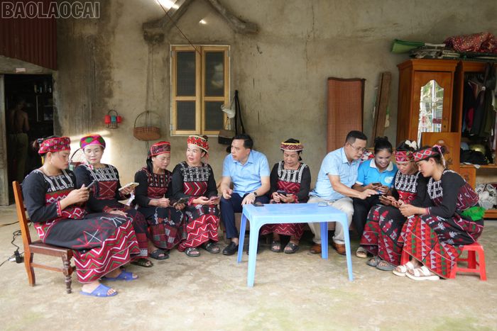  Lãnh đạo Mặt trận Tổ quốc và Trung tâm Phục vụ hành chính công xã Bảo Hà hướng dẫn bà con thôn 2 Nhai Thổ sử dụng dịch vụ công trực tuyến trên điện thoại. 