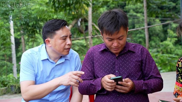  Ông Nguyễn Ngọc Thắng - Chủ tịch Ủy ban Mặt trận Tổ quốc Việt Nam xã Bảo Hà hướng dẫn người dân thôn 2 Nhai Tẻn đăng nhập VNeID trên điện thoại. 