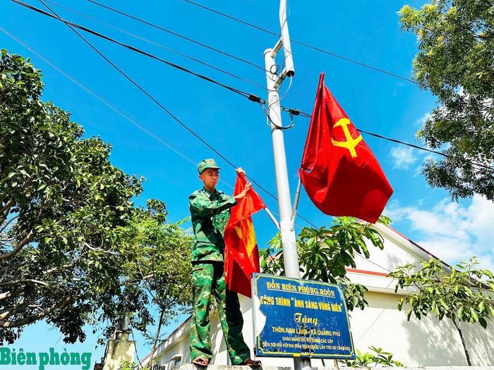 Chi đoàn Đồn Biên phòng Roòn phối hợp với địa phương treo cờ Tổ quốc tại các trục đường liên thôn thuộc xã Phú Trạch. Ảnh: Anh Quân