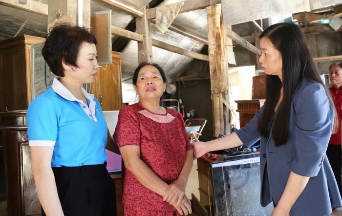 Bà Bình (đứng giữa) kể lại thời điểm nước lũ dâng lên với Phó Chủ tịch Hội LHPN Việt Nam Nguyễn Thị Thu Hiền (bìa phải) và bà Triệu Thị Tình, Phó Chủ tịch Hội LHPN tỉnh Tuyên Quang