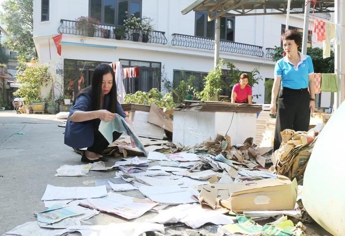 Phó Chủ tịch Hội LHPN Việt Nam Nguyễn Thị Thu Hiền (bên trái) đang phơi lại sách vở cho học sinh