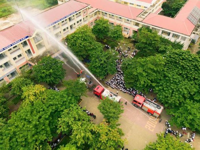Giáo viên và học sinh Trường THPT Trần Suyền xem trình diễn thao tác kỹ thuật phun nước chữa cháy.