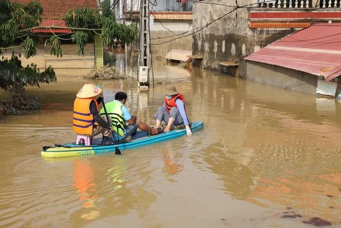 Người dân xã Đa Phúc tranh thủ trời nắng quay lại nhà để trục vớt tài sản bị ngập