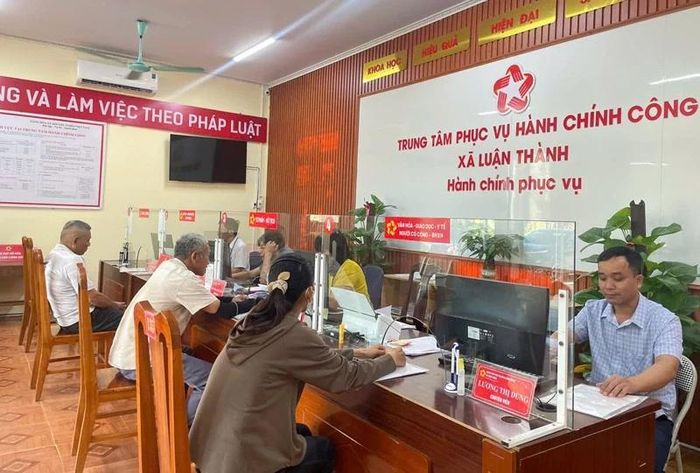 Cán bộ, công chức Trung tâm PVHCC xã Luận Thành phục vụ Nhân dân đến làm các TTHC.