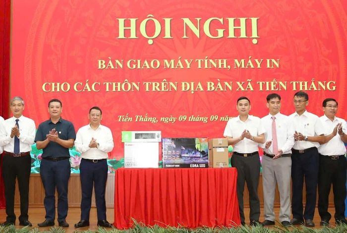 Bí thư Đảng ủy, Chủ tịch HĐND xã Hoàng Anh Tuấn trao hệ thống máy tính, máy in cho các thôn trên địa bàn. Ảnh: Hoàng Sơn