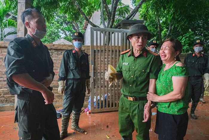 Bà Phạm Thị Dung, thôn Giếng Chảnh (xã Đồng Kỳ) nắm chặt tay Thiếu tá Phạm Viết Thắng, Phó Trưởng Công an xã Đồng Kỳ chia sẻ về trận lũ lụt vừa qua.