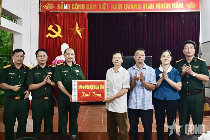 Đại tá Trần Anh Tuấn, Phó tổng biên tập Báo Quân đội nhân dân trao quà tặng bà con thôn Khau Diều, xã Bình Yên, tỉnh Thái Nguyên. Ảnh: VIỆT TRUNG 