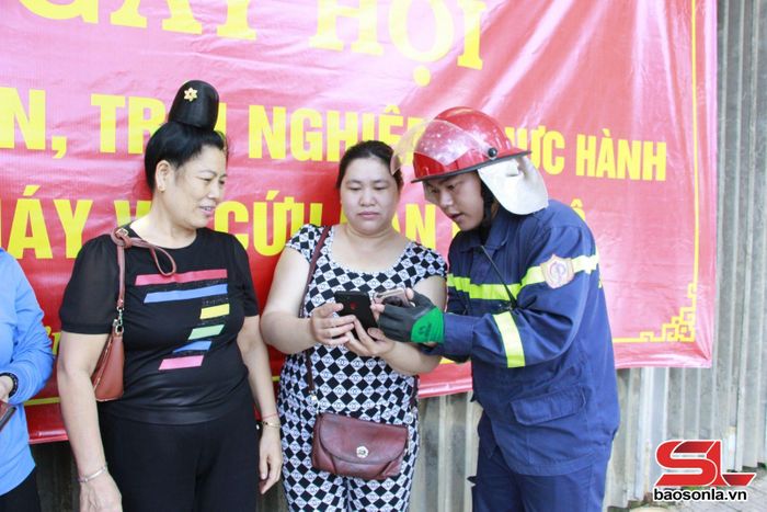 Cán bộ, chiến sĩ Phòng Cảnh sát PCCC và CNCH tuyên truyền tiểu thương chợ Trung tâm Thành phố hướng dẫn sử dụng App báo cháy 114.