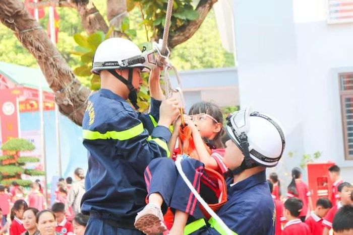 Các em học sinh được các cán bộ chiến sỹ hướng dẫn thoát nạn