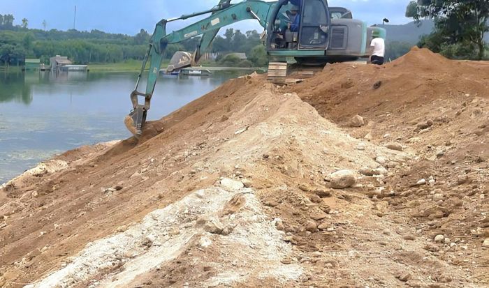 Ông Kiên dùng máy múc lấn chiếm lòng hồ. Ảnh: T.H