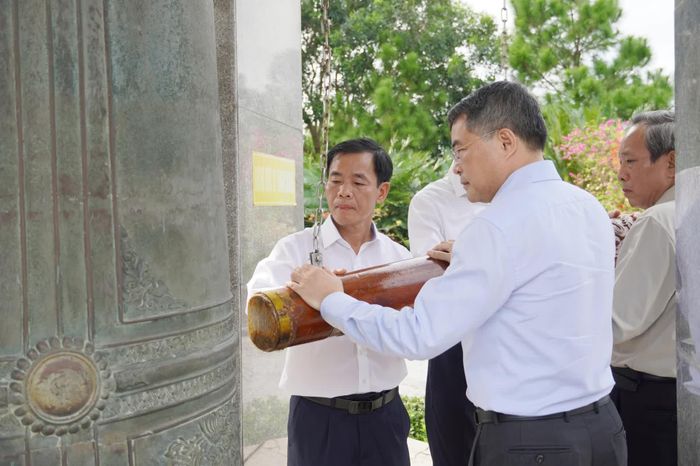 Các đại biểu thực hiện nghi thức thỉnh chuông tại Nghĩa trang liệt sĩ quốc gia đường 9 - Ảnh: X.P