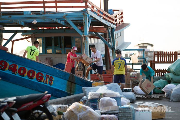 Người dân tất bật bốc xếp hàng hóa, vận chuyển nhu yếu phẩm phục vụ đời sống trên đảo.