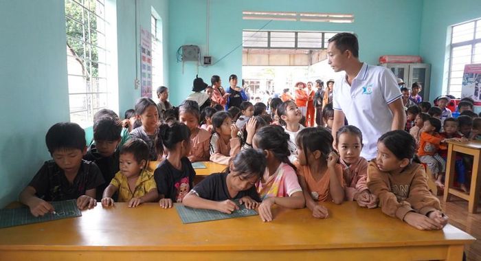  Thầy Lê Văn Bình hướng dẫn em đã biết chữ học tiếng Anh. Ảnh: Chu Hằng 
