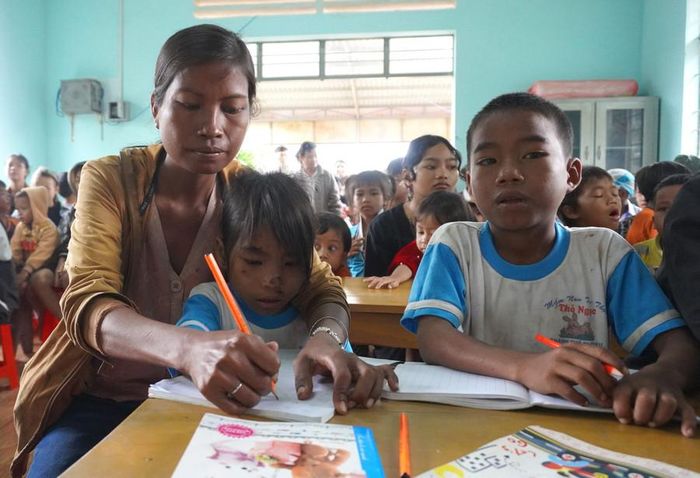  Ba mẹ con chị Kpuih Phơi cùng theo học lớp xóa mù chữ ở làng Khôi. Ảnh: Chu Hằng 