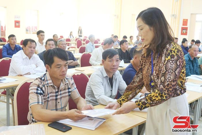 Cán bộ Sở Tư pháp phát tài liệu tuyên truyền kiến thức pháp luật, kỹ năng, nghiệp vụ hòa giải cho hòa giải viên xã Long Hẹ.