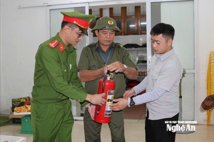 Ông Phạm Trọng Tạo tham gia cùng Công an phường Trường Vinh hướng dẫn người dân sử dụng bình chữa cháy. Ảnh: Phạm Thủy