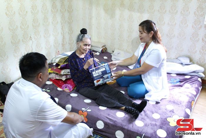 Các y, bác sĩ Trạm y tế phường Chiềng Cơi tặng thuốc bổ cho người cao tuổi bản Chậu Cọ. 