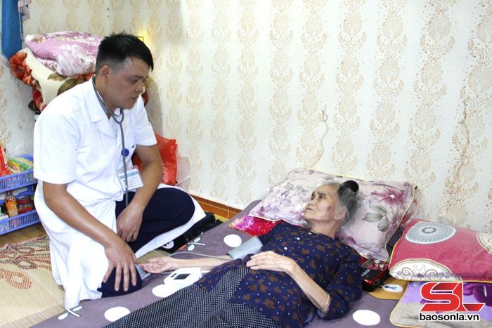 Các y, bác sĩ Trạm y tế phường Chiềng Cơi thăm khám bệnh cho người cao tuổi. 