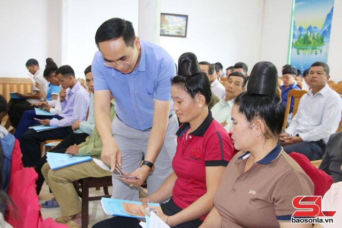Cán bộ Trung tâm TGPL Nhà nước tỉnh phát sổ tay trợ giúp pháp lý cho nhân dân xã Quỳnh Nhai.