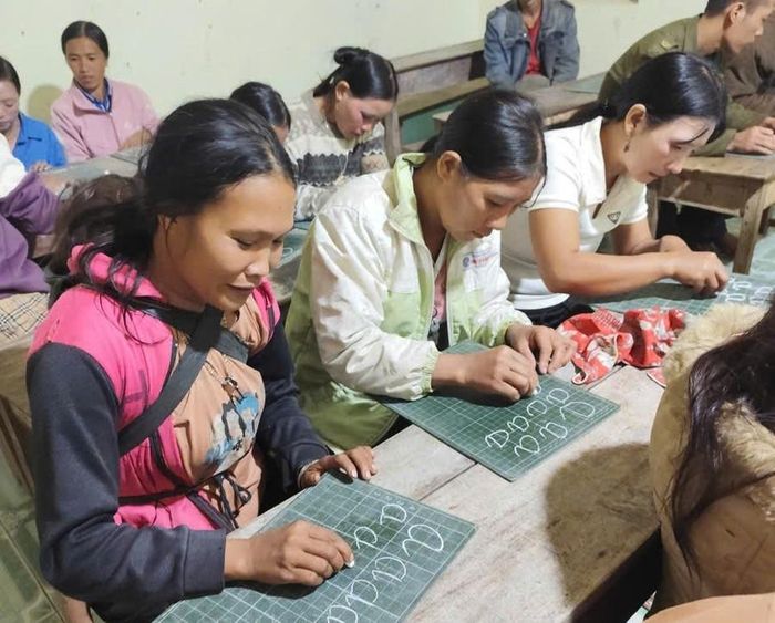 Chị Ly Mì Đô, bản Xà Hồ địu con đến lớp xóa mù chữ.