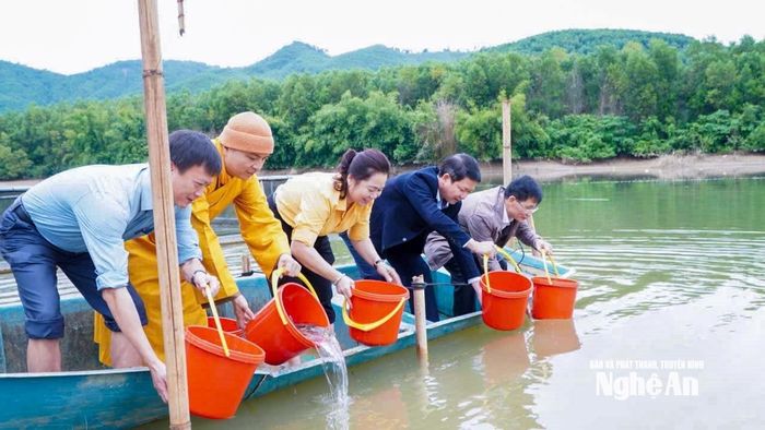 Các đại biểu tham gia thả cá giống xuống hồ Châu Thắng. Ảnh: Đình Tuyên