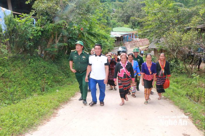 Vợ chồng anh Lương Văn Tho - chị Lương Mẹ Lư (giữa) cùng BĐBP và bà con dân bản. Ảnh: K.L