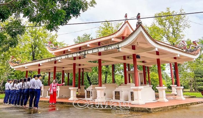 Thuyết minh viên giới thiệu cho khách tham quan về khu mộ của gia đình nông dân Mười Chức.