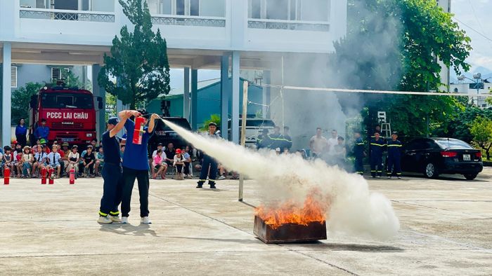 Cán bộ Phòng Cảnh sát Phòng cháy, chữa cháy và Cứu nạn, cứu hộ hướng dẫn người dân thực hành chữa cháy.