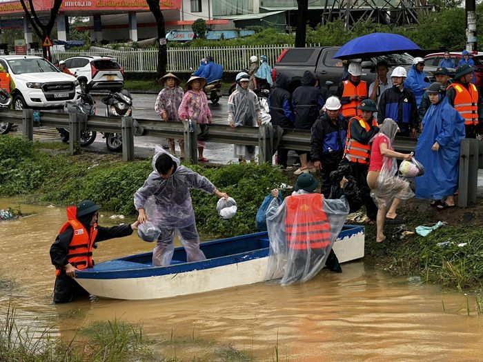 Lực lượng chức năng di chuyển người dân ra khỏi các khu vực ngập lũ nguy hiểm tại phường Hòa Xuân