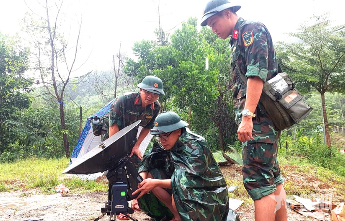 Bộ đội Lữ đoàn Thông tin 575 làm nhiệm vụ bảo đảm thông tin liên lạc trong mưa trên vùng núi Trà My (TP Đà Nẵng). Ảnh: QUANG HÙNG