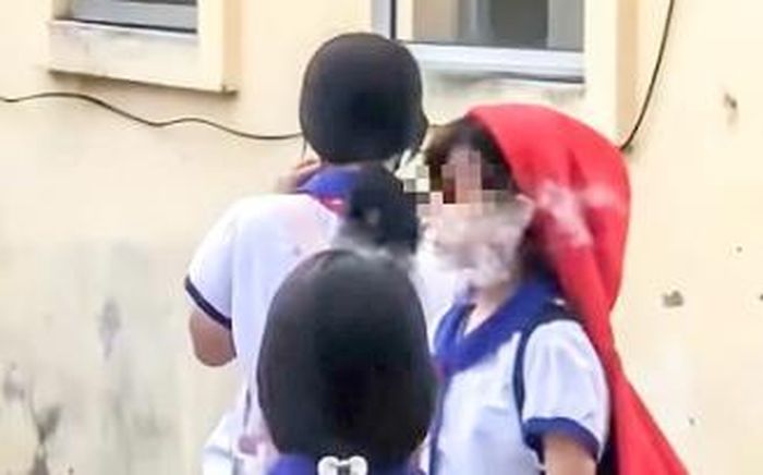 Nhóm nữ sinh tiểu học đứng hút thuốc trong sân trường