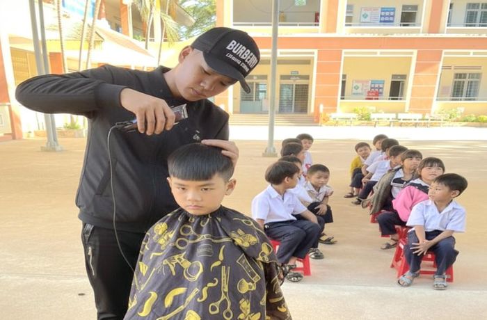 Cắt tóc miễn phí cho các em học sinh Trường Tiểu học Anh hùng Núp ngay tại trường. Ảnh: Ngọc Duy 