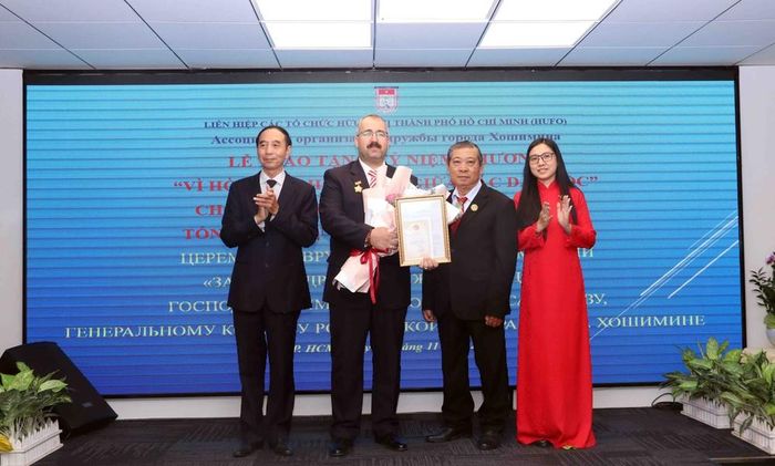 Các đại biểu chúc mừng ông Timur Sirozhevich, Tổng Lãnh sự Liên bang Nga tại Thành phố Hồ Chí Minh, nhận Kỷ niệm chương "Vì hòa bình, hữu nghị giữa các dân tộc” của Liên hiệp các tổ chức hữu nghị Việt Nam. Ảnh: Xuân Khu- TTXVN