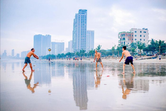 Người dân chơi thể thao tại bãi biển Mân Thái lúc sáng sớm. Ảnh: BẢO LÂM