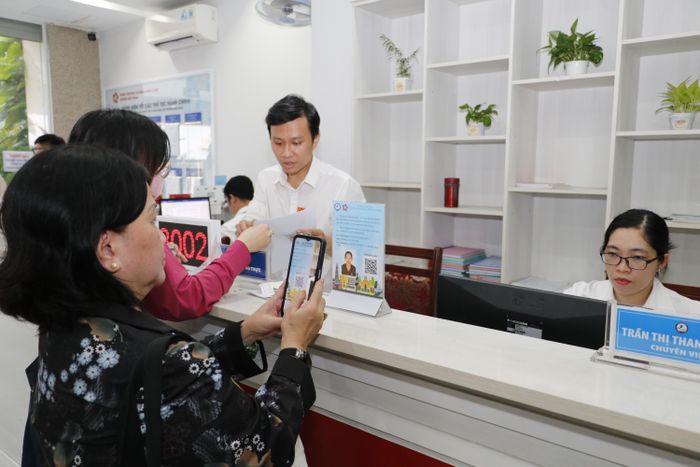 Người dân quét mã QR đánh giá công chức phường Bến Thành (TPHCM). Ảnh: NGÔ BÌNH
