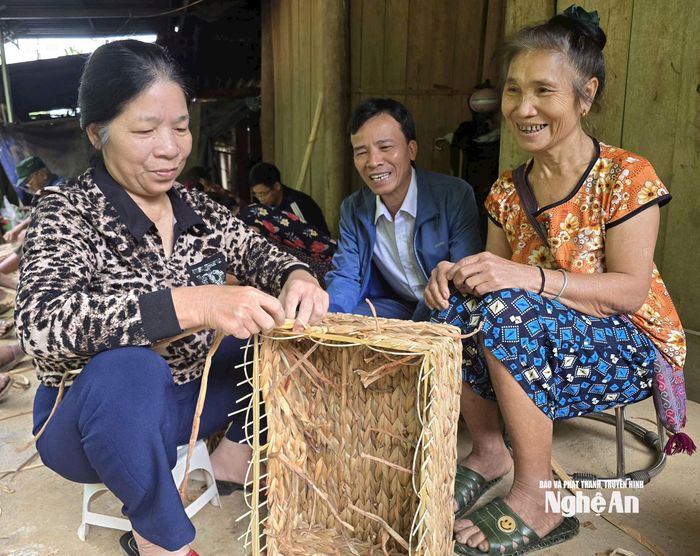 Ông Nguyễn Văn Hòe xem nghệ nhân đan bèo (góc trái ảnh), đang truyền nghề cho bà con bản Văng Cuộm. Ảnh: Tiến Hùng