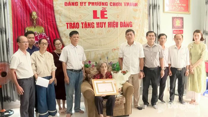 Thường trực Đảng ủy phường Chơn Thành trao quyết định của Tỉnh ủy Đồng Nai và gắn Huy hiệu 45 năm tuổi Đảng cho đảng viên Từ Thị Hồng Lý. Ảnh: Đỗ Trình