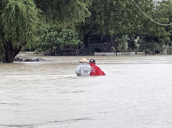 Người dân thôn Văn Lâm 3, xã Phước Nam chủ động ra khỏi vùng bị ngập lụt. Ảnh: Công Thử - TTXVN