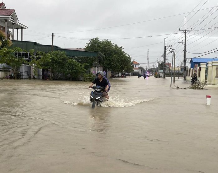 Nước lũ tràn qua đường giao thông liên xã nối Thuận Nam với Phước Dinh. Ảnh: Công Thử - TTXVN