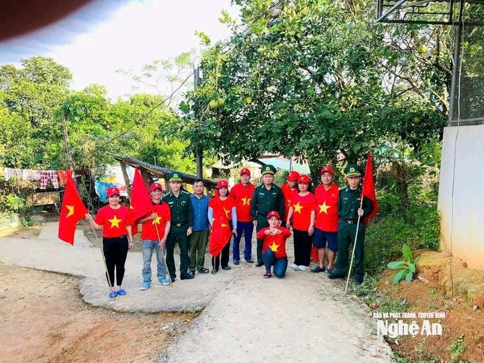 Đồn Nậm Càn phối hợp tặng cờ Tổ quốc cho bản Nậm Càn. Ảnh: Trần Văn Khánh