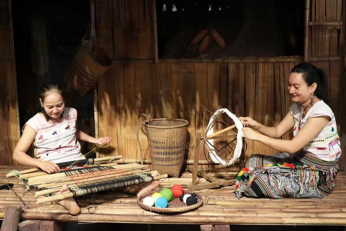 Nghệ nhân Ka Rỉn (trái) và con gái Ka Hương dệt thổ cẩm tại Bảo tàng Phụ nữ Nam bộ. Ảnh: Khánh Châu
